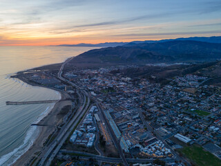 Ventura California Drone Aerial view at Sunset with city Lights appearing near the ocean and broad-walk pier