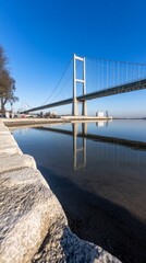 Suspension bridge reflecting, winter waterfront
