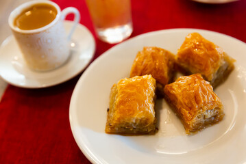 Traditional Turkish dessert - baklava on a plate and a cup of coffee