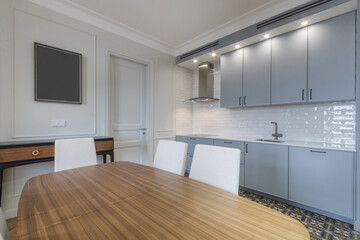 The interior of the kitchen with a stylish design. White wall decor, blue kitchen set with built-in...