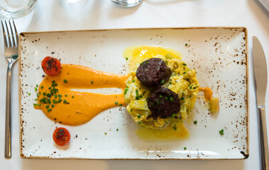 Top view of Catalan style green beans cooked with scrambled eggs and blood sausage garnished with...
