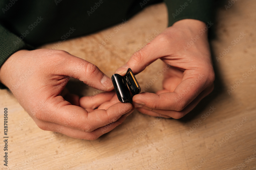 Poster top view of technician carefully replacing battery of smartwatch using specialized tools, highlighti