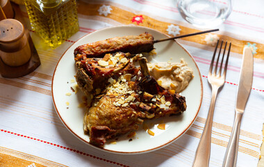 Delicious baked lamb with lula kebab on wooden skewer and spicy yogurt dip served for dinner in traditional Albanian restaurant..