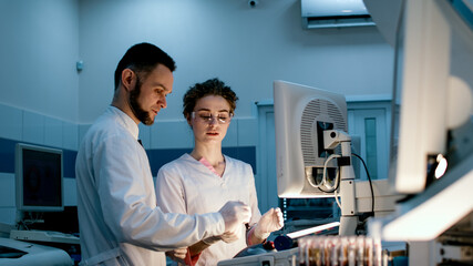 Fototapeta premium Research scientists work in a laboratory with modern equipment. Analyzes samples and genetic material using special machines in a modern laboratory. Concept of scientific research.