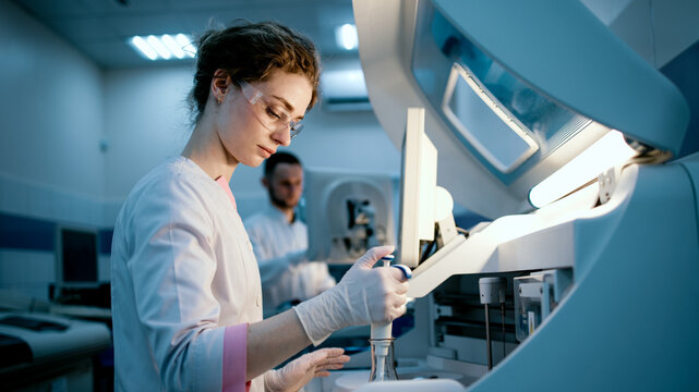 Research scientists work in a laboratory with modern equipment. Analyzes samples and genetic material using special machines in a modern laboratory. Concept of scientific research.