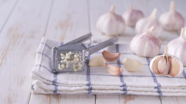 Close-up of garlic bulbs on a wooden table with garlic blur background. Peeled garlic bulbs on white wooden table.
