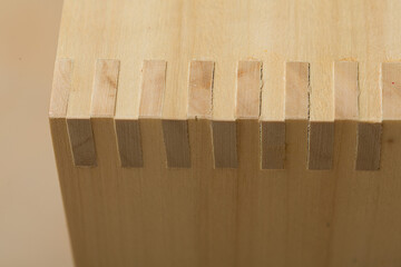 Tan birch light wood plywood plain varnished veneer drawer corner box joint joinery with a woodgrain texture suitable for a dynamic texture or background.