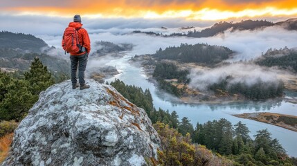 Obraz premium Hiker atop rocky summit, sunrise view over misty river valley