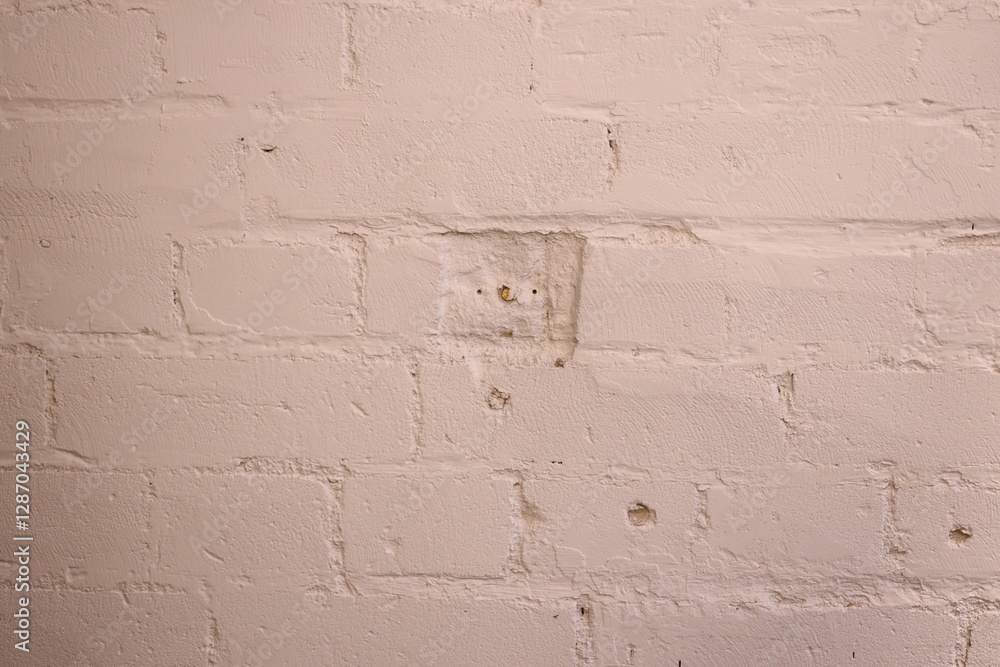 Poster a close-up shot of a worn-out white brick wall with a noticeable hole in it, suitable for use in arc