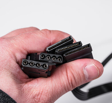 hand holding sata and molex power connectors for pc components.