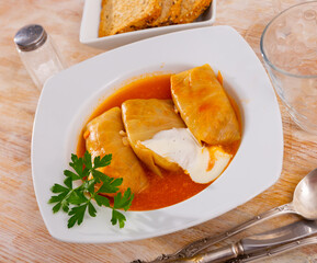 Russain traditional dish, golubtsy (cabbage rolls), served on table, flavoured with smetana and...
