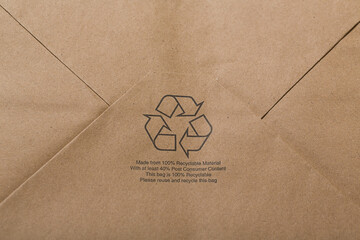 Recyclable craft paper shopping bag background with a printed reuse and recycle logo. Can be used for a mockup for design.