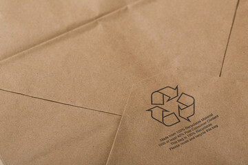 Recyclable craft paper shopping bag background with a printed reuse and recycle logo. Can be used for a mockup for design.