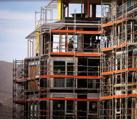 Far shot of a construction worker working in a large commercial building under contruction