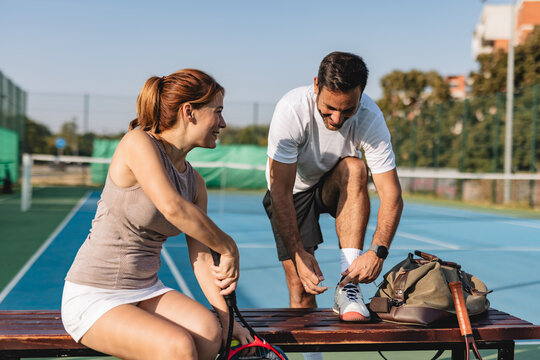 Young couple playing tennis outdoors enjoying a fun summer game