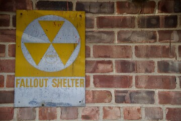 A old fallout shelter sign on brick wall