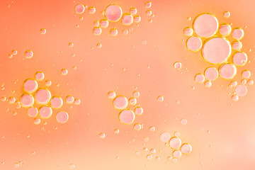 Beautiful cosmetic background. Soft orange abstract oil bubbles or face serum background. Oil and...