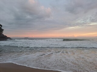 Um pôr-do-sol durante um dia nublado com muitas cores no céu, na praia do Félix, em Ubatuba, litoral norte paulista, Brasil.
