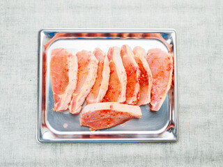 Juicy pork chops on a metal tray. Meat in red spicy sauce. Food preparation and enchanting taste. Popular product.