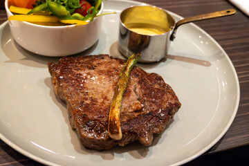 Large beef rib eye steak grilled on gas stove in German restaurant