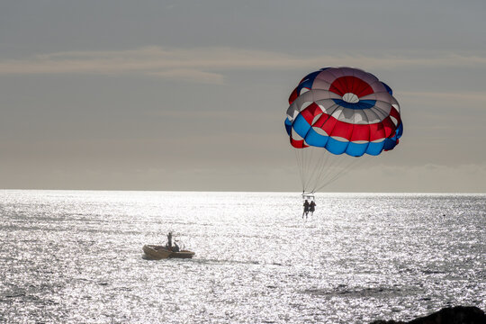 Parasailing or parascending recreational water sport with boat on Tenerife, Costa de Adeje, adventure for tourists