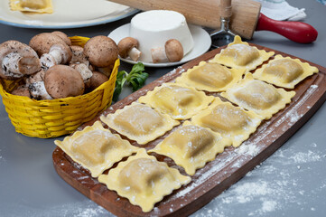 Italian food, fresh home made stuffed pasta ravioli dumplings with ricotta soft cheese and champignons porcini mushrooms, Parma, Emilia Romagna, Italy
