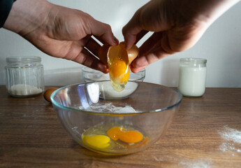 Cooking Scrambled eggs, omelette, pancakes. Raw eggs in glass bowl. Cracking eggs.