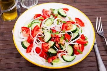 Delicious vegetable salad with tomato, cucumber and onion on plate