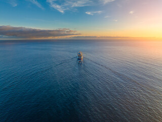 Luxury cruise ship sailing at sunset through the calm waters near Madeira in Funchal