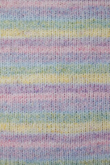 Fototapeta premium knitted background color melange lilac yellow pink green from fluffy fleece yarn. Cozy knitted clothes in spring shades.