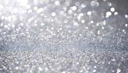 Fototapeta premium Shimmering platinum glitter texture background with soft light reflections. Silver bokeh background with softly blurred glowing lights