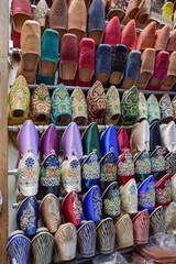 Slippers or sandals of many colors hung from street stalls in Marrakech's souk