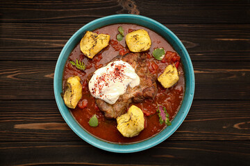 Pork steak in tomato-pepper sauce with baked potatoes