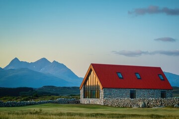 Obraz premium Scenic mountain landscape featuring a modern stone house against a backdrop of majestic peaks during sunset in a tranquil rural setting