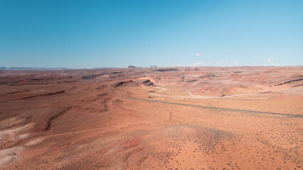 Drone view of a road in the middle of a desert environment, cars on the road