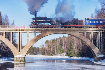 Retro train moves above the river.