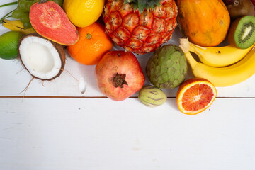 Summer mix of tropical fruits over white wooden background
