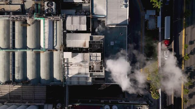 Top view of the brewery plant with chimneys and tanks. Drone camera with top view moves over the plant