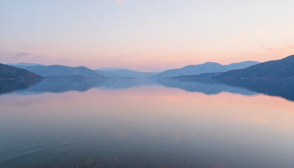 Obraz premium Serene lake landscape reflecting mountains at sunset