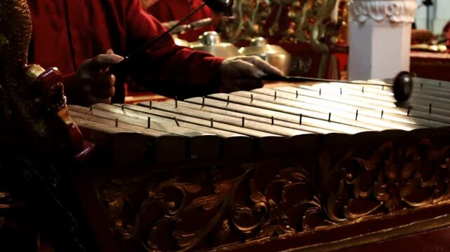 A professional gambang player plays the gambang one of the gamelan instruments in a wayang performance