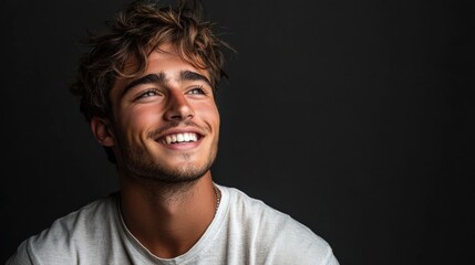 Naklejka premium Smiling young man in casual beige t-shirt and glasses, quarter view,portrait with soft lighting
