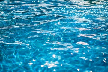 Blue swimming pool water background. Blue swimming pool with sun reflections.