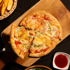 Individual Pepperoni Pizza on a Rustic Wooden Serving Board: A Close-Up Shot of a Small Pepperoni Pizza Cut into Four Slices, Displayed on a Light-Colored Wooden Board with a Side of French Fries and 