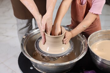 Hobby and craft. Mother with her daughter making pottery indoors, closeup