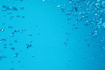 Many water bubbles on blue background, closeup