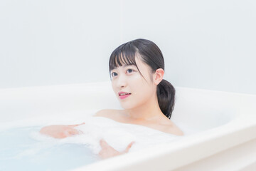 Obraz premium お風呂でお湯に浸かる若い女性
