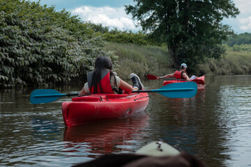 People from behind on kayaks on a river