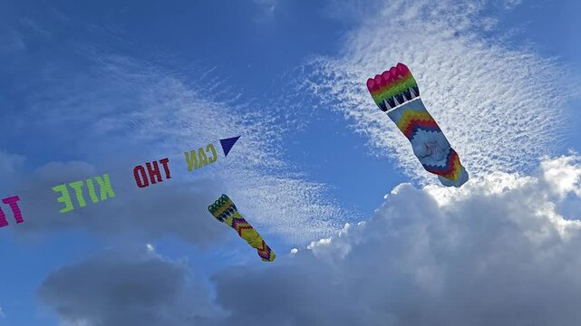 A large colorful kite soars high in the clear blue sky, tethered by a thin string.	

