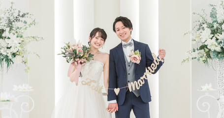 結婚式場でガーランドを持つ新郎新婦（ブライダル・ウェディング） 