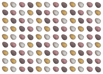 Easter pattern background made of chocolate quail egg shaped candies 